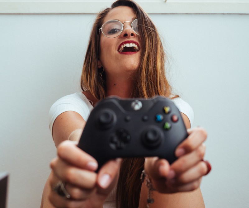Mädchen mit Xbox controller in der hand, Brille, rote lippen