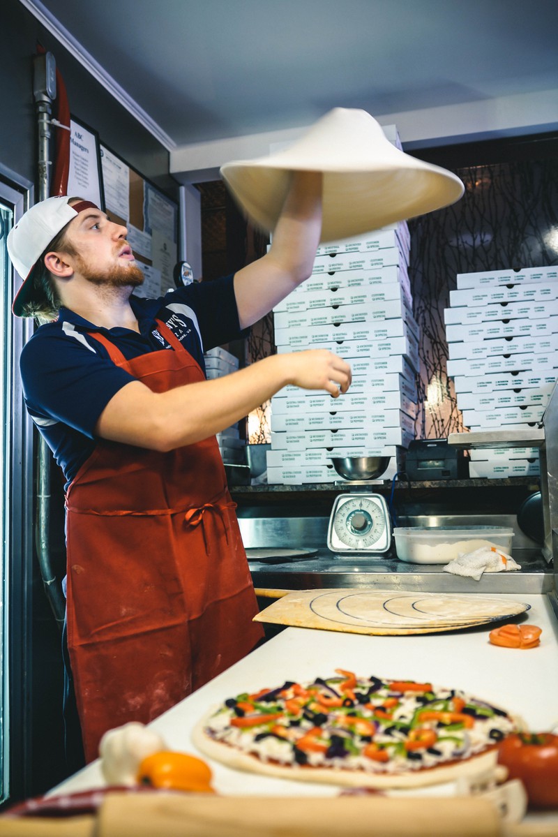 Mann der Pizza backt