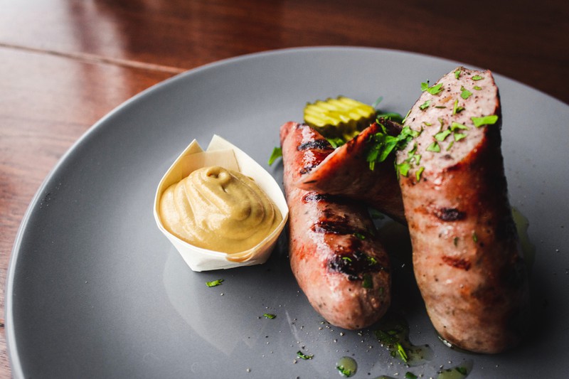 Man sieht die Gin-Tonic-Bratwurst, die fertig serviert ist und bestimmt alle Geschmäcker trifft