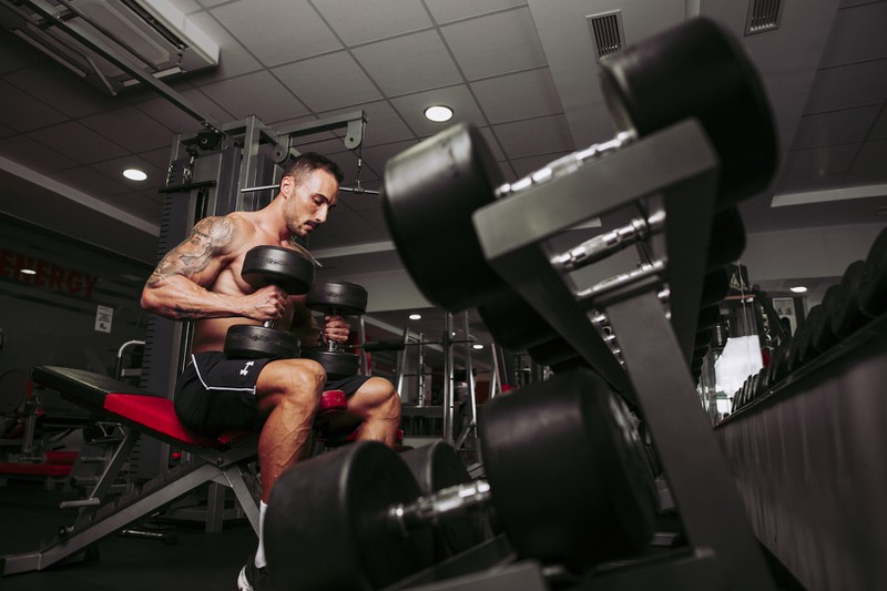 Ein Mann, der im Fitnessstudio trainiert, während er sich vermutlich an die Regeln hält.
