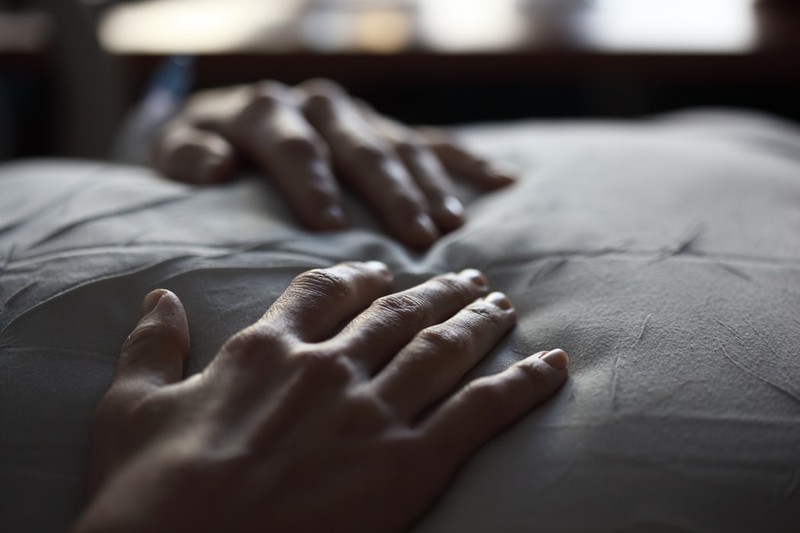 Ein Mann, der im Bett liegt und dessen Spermien fruchtbar sein müssen, wenn er ein Kind zeugen möchte