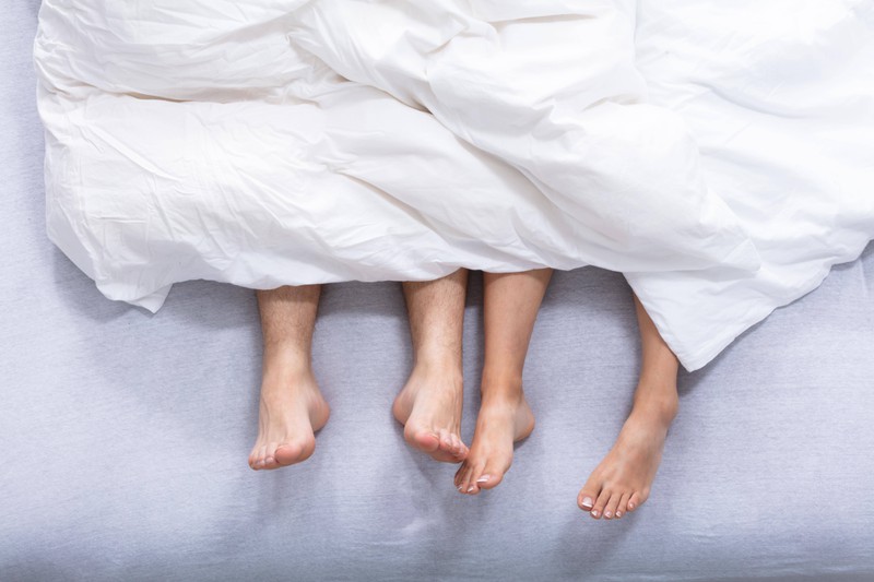 Füße von einem Paar im Bett