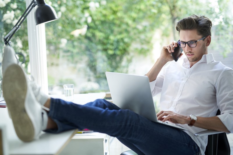 Ein Mann sitzt am Schreibtisch mit dem Laptop auf dem Schoß was zu langsamerem Sperma führen soll