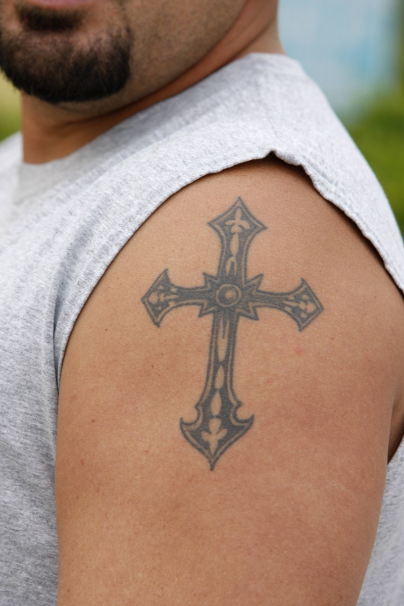 Ein Mann mit einem kleinen Kreuz-Tattoo