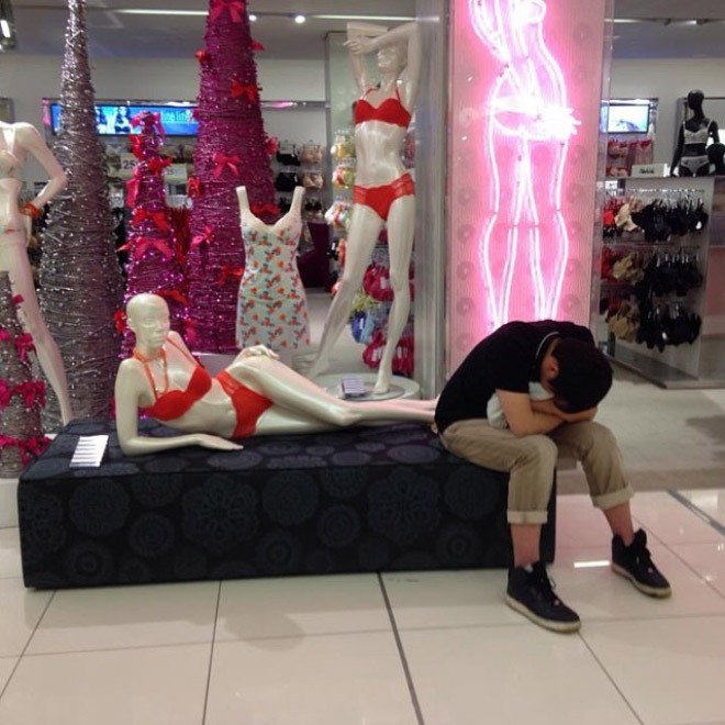 Verzweifelter Mann wartet auf seine Frau, während sie shoppt.