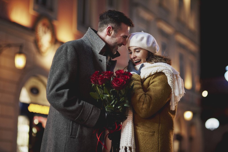 Ein Mann schenkt seiner Freundin Rosen zum Valentinstag.