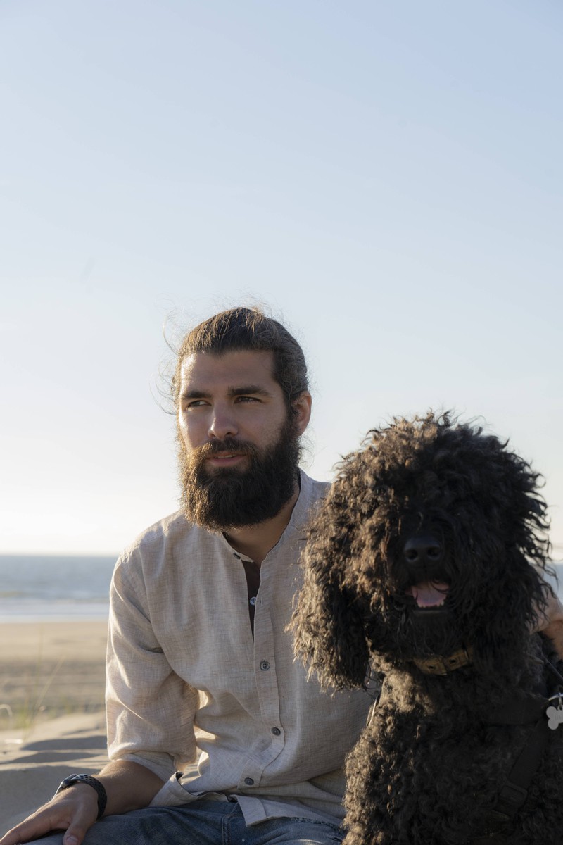 Das Foto illustriert einen Mann mit Bart und Hund, wobei der Hund nicht so dreckig ist wie der Bart