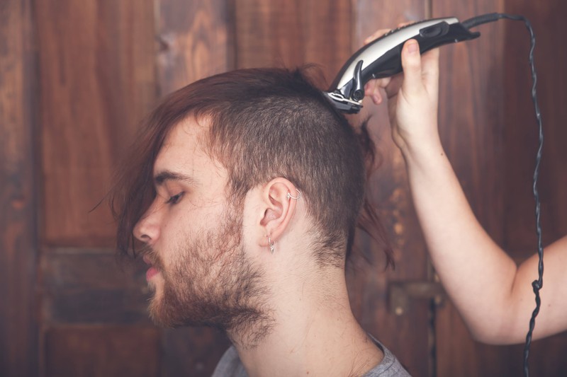 Einem Mann werden zuhause die Haare geschnitten