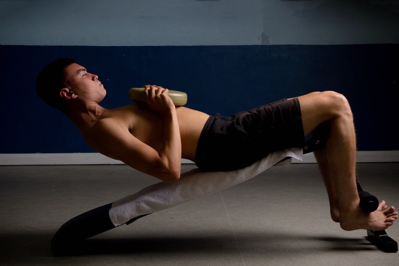 Sit-ups mit Gewicht intensivieren das Training.