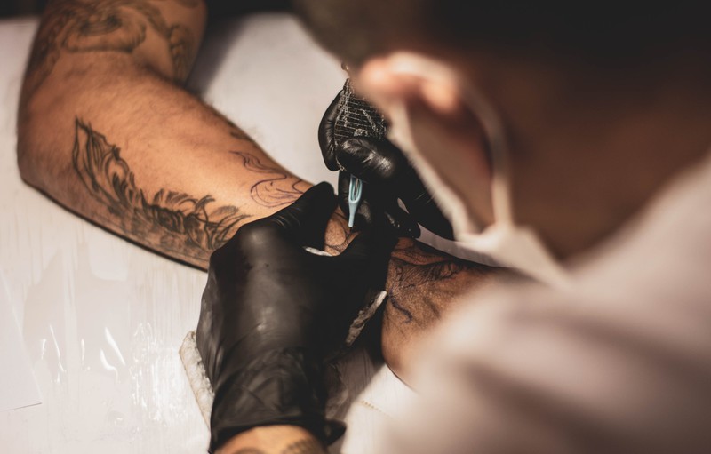 Ein Mann bekommt ein neues Tattoo und muss es danach pflegen