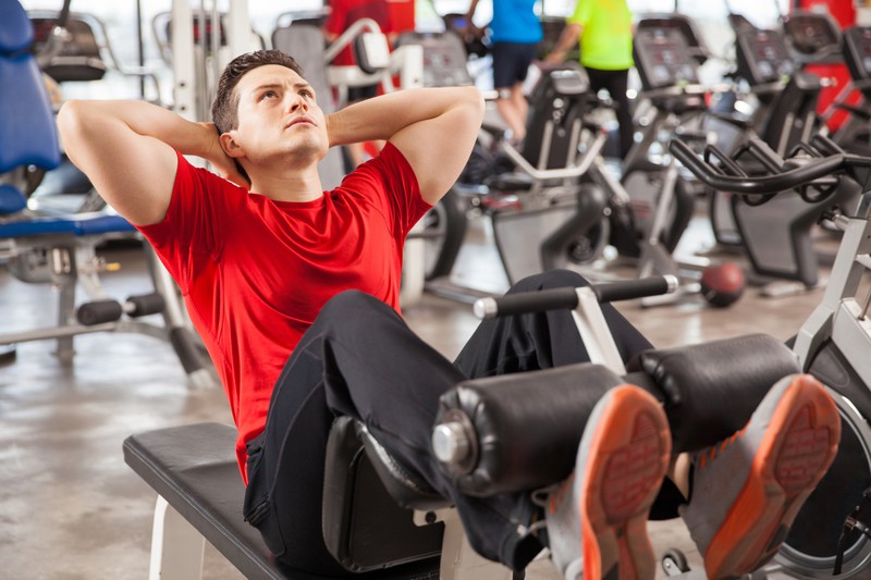 Das Foto zeigt einen Mann, der für seine Bauchmuskeln ins Fitnessstudio geht, um zu trainieren