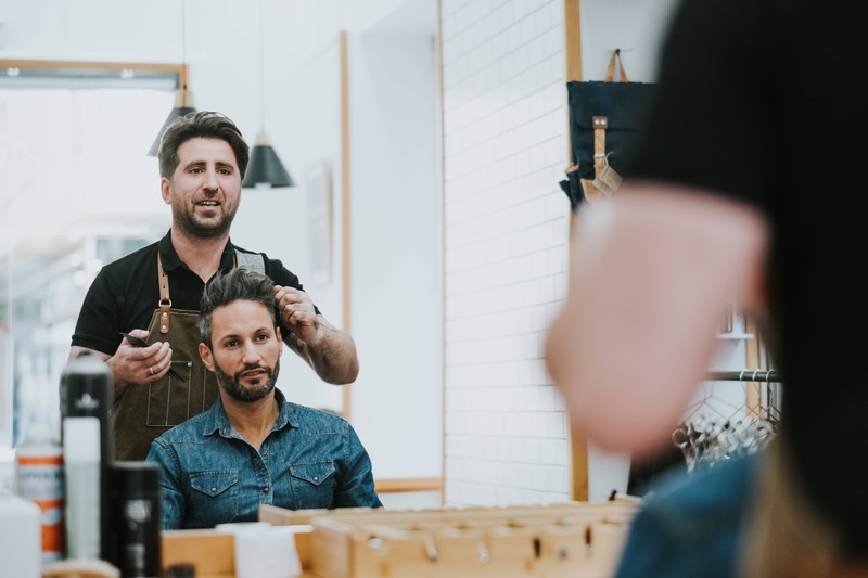Ein Foto eines Mannes, der zum Friseur geht, um sich eine Trendfrisur scheiden zu lassen.