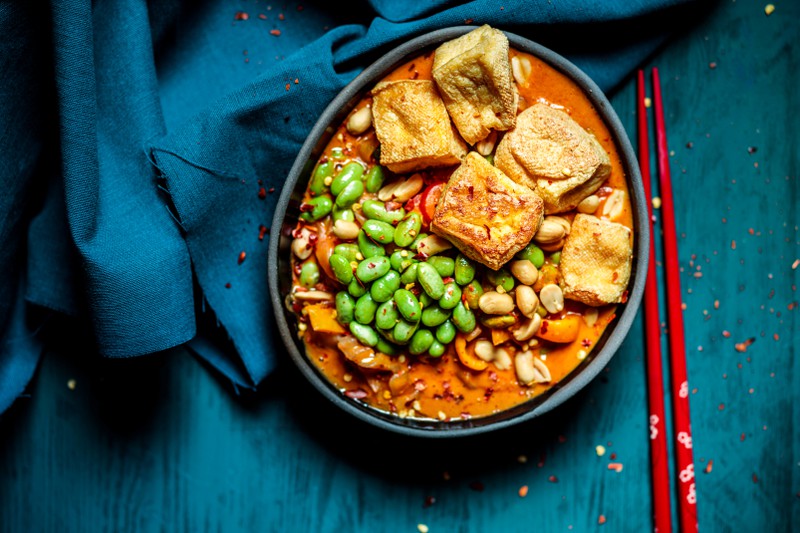 Schale mit verzehrfertigem veganem Curry mit Edamame und Tofu