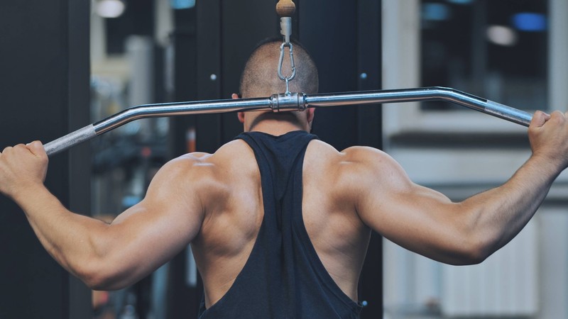 Zu sehen ist ein Mann, der im Fitnessstudio trainiert.