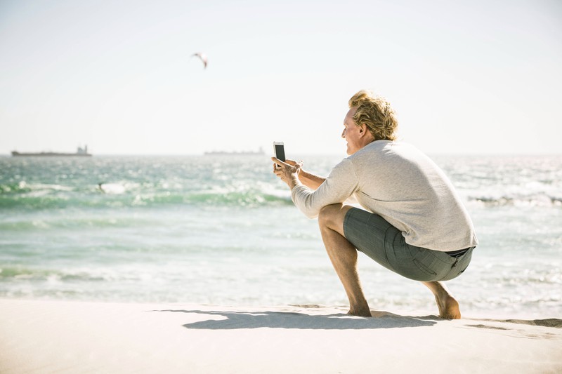 Zu sehen ist ein Mann, der ein Bild am Strand macht und es geht um Instagram-Boyfriends