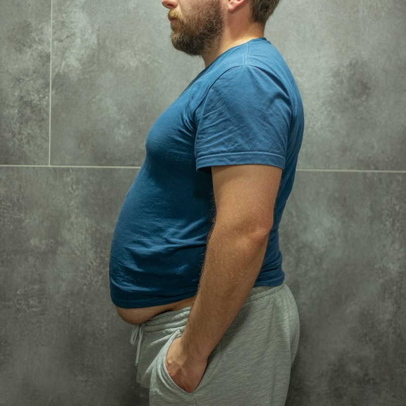 Ein Mann mit Bauchfett leidet unter wenigen Hormonen.